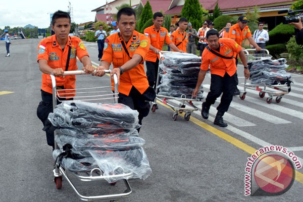 Anggota Basarnas membawa 200 kantung jenazah untuk dibawa pesawat patroli maritim CN235 TNI AL menuju Pangkalan Bun Kalteng, di Bandara Depati Amir Pangkal Pinang Bangka Belitung, Selasa (30/12). (ANTARA FOTO/Eric Ireng).